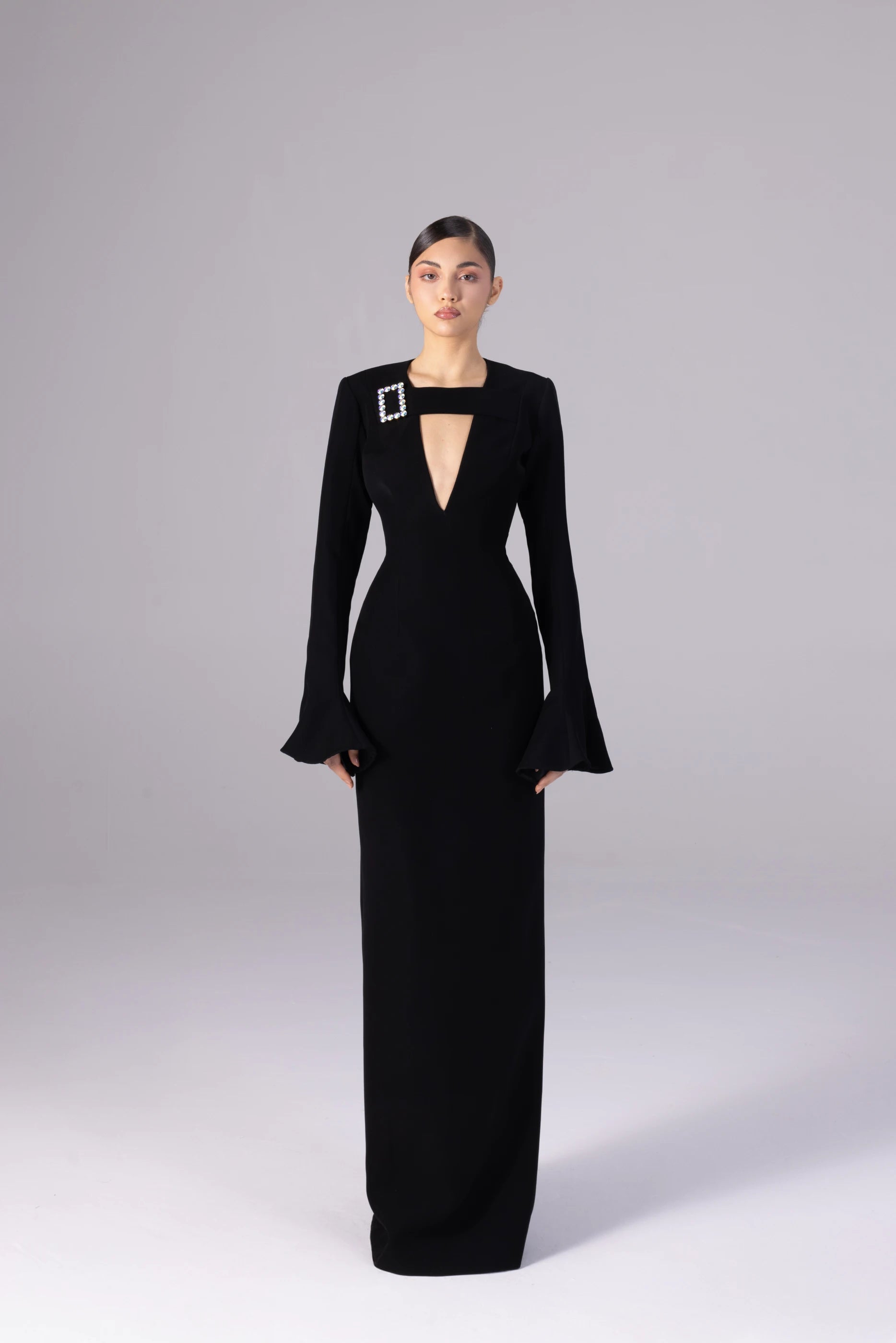 Black evening gown with a unique design on a gray background